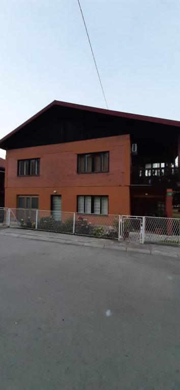 un bâtiment avec une clôture en face d'une rue dans l'établissement Apartman Nina, à Visoko