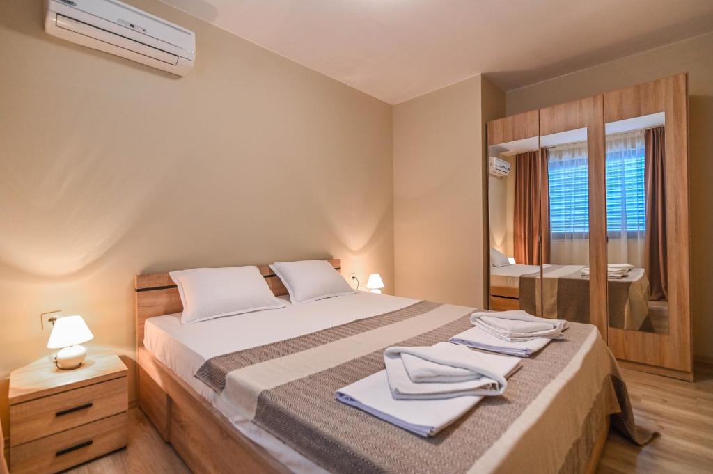 a bedroom with a large bed with towels on it at Apart-Hotel Onegin & Thermal Zone in Sozopol