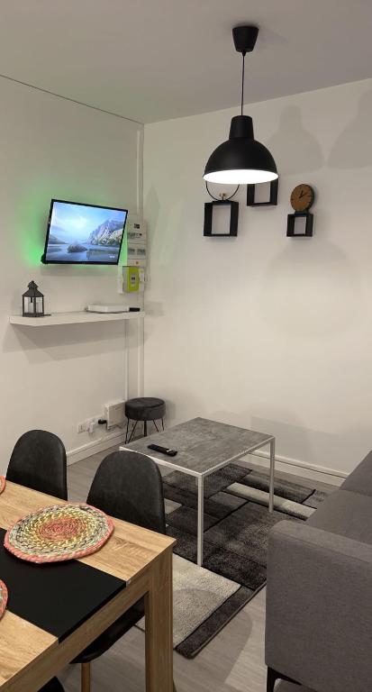 Coudekerque-BrancheAppartement moderne refait à neuf proximité centre ville et plage的客厅配有桌子,墙上配有电视