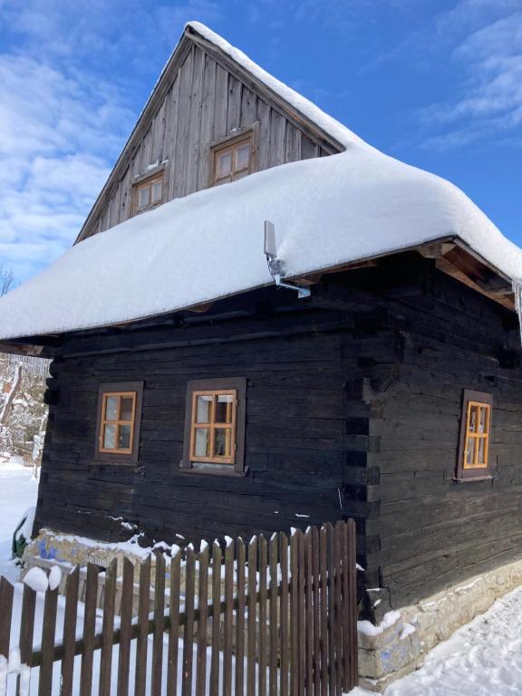 a wooden cabin with snow on the roof at Drevenička Dorotka in Terchová