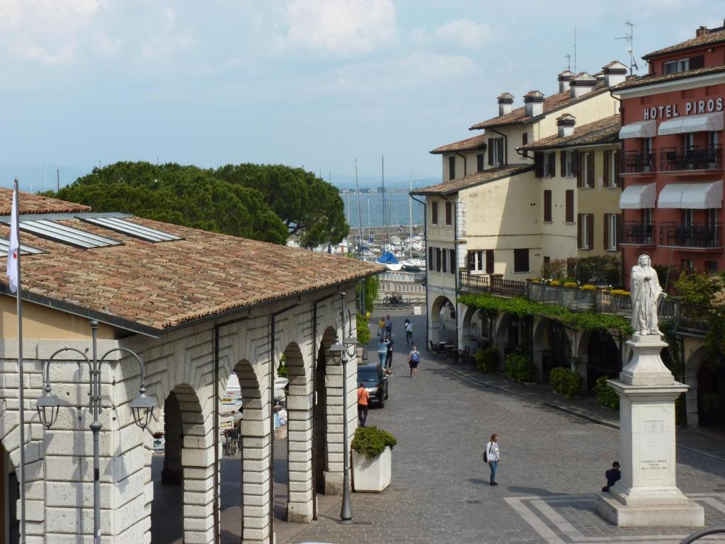 a street in a town with buildings and a statue at Appartamento palazzo del Provveditore vista lago in Desenzano del Garda