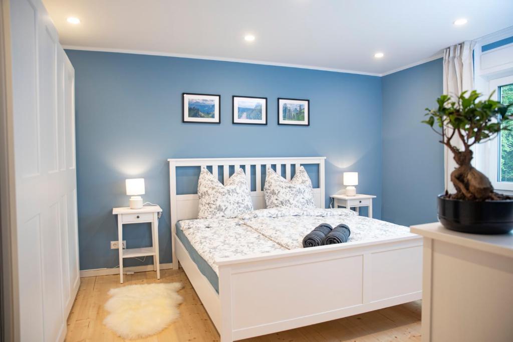 a bedroom with blue walls and a white bed at Moderne Wohnung im Grünen mit privatem Garten in Donaueschingen