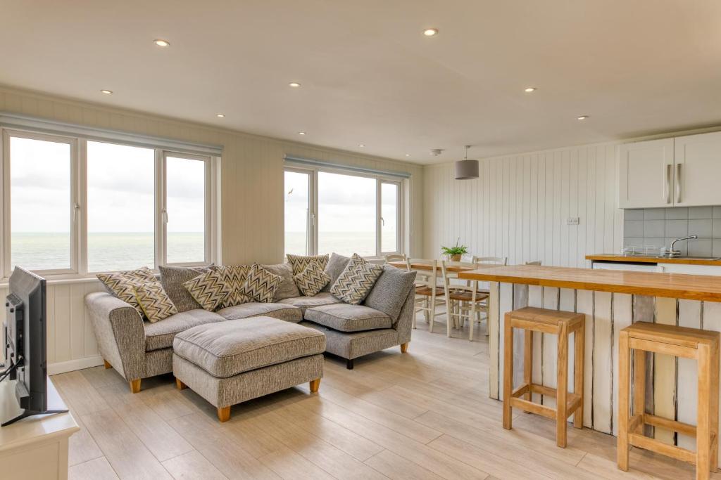 uma cozinha e sala de estar com um sofá e uma mesa em Granville Marina: Stunning sea view property with easy parking em Ramsgate