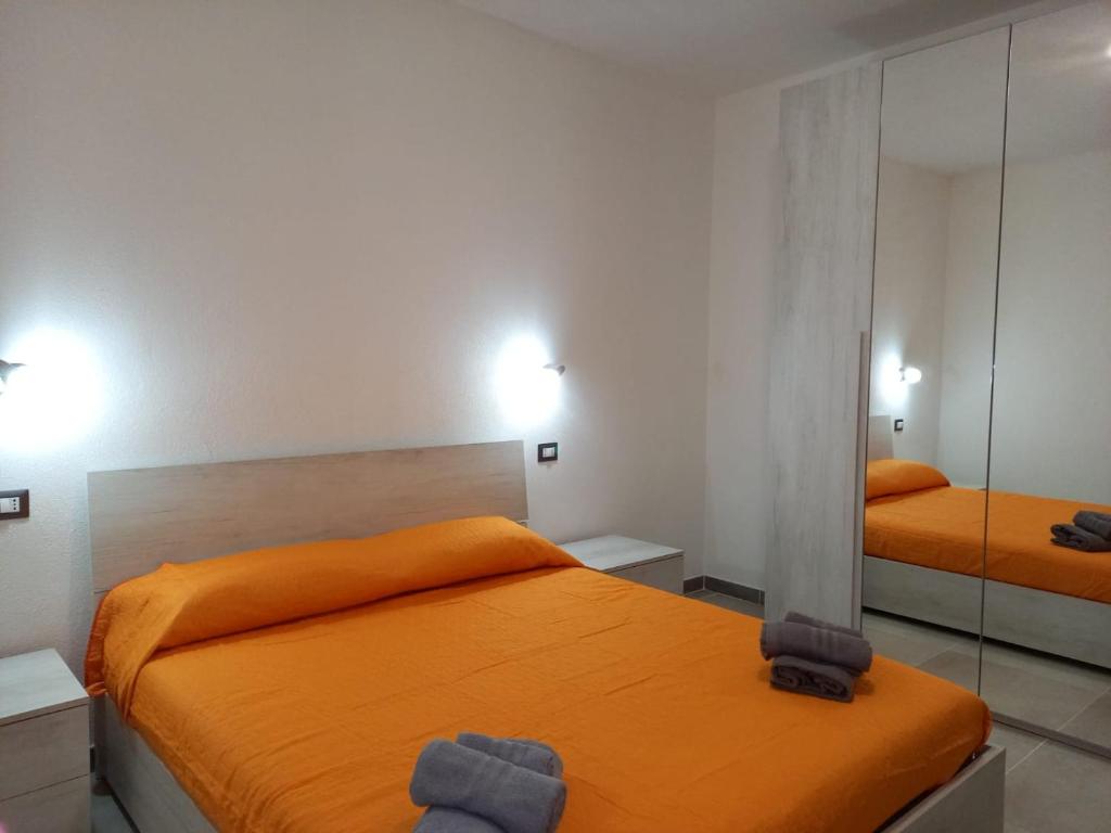 1 dormitorio con 2 camas y espejo en La casa di Isa, en Maracalagonis