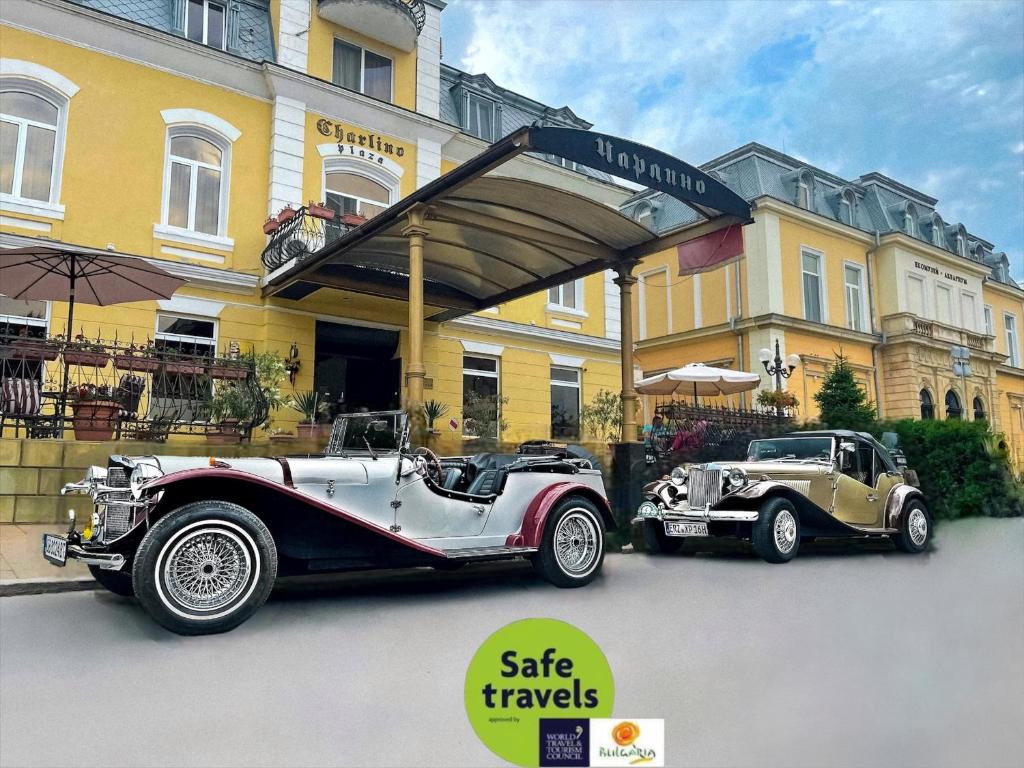 two old cars parked in front of a building at Charlino Plaza in Ruse