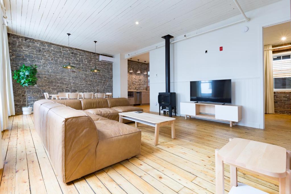 sala de estar con sofá y TV en La Maison des Lofts - Par les Lofts Vieux-Quebec, en Quebec