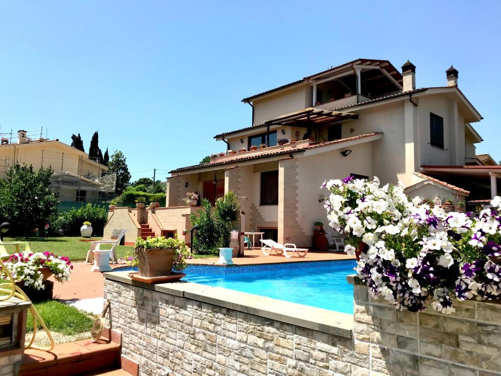 a villa with a swimming pool in front of a house at Casa Vacanze Neri in Scandicci