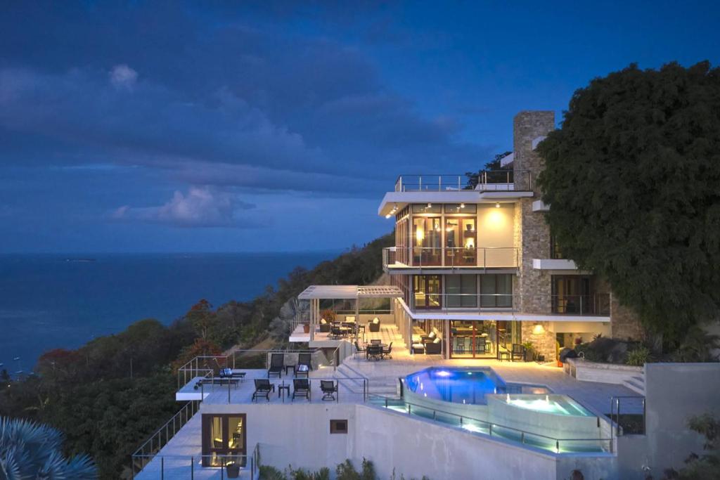 a large house with a swimming pool at night at Happy Days Villa A in Fajardo