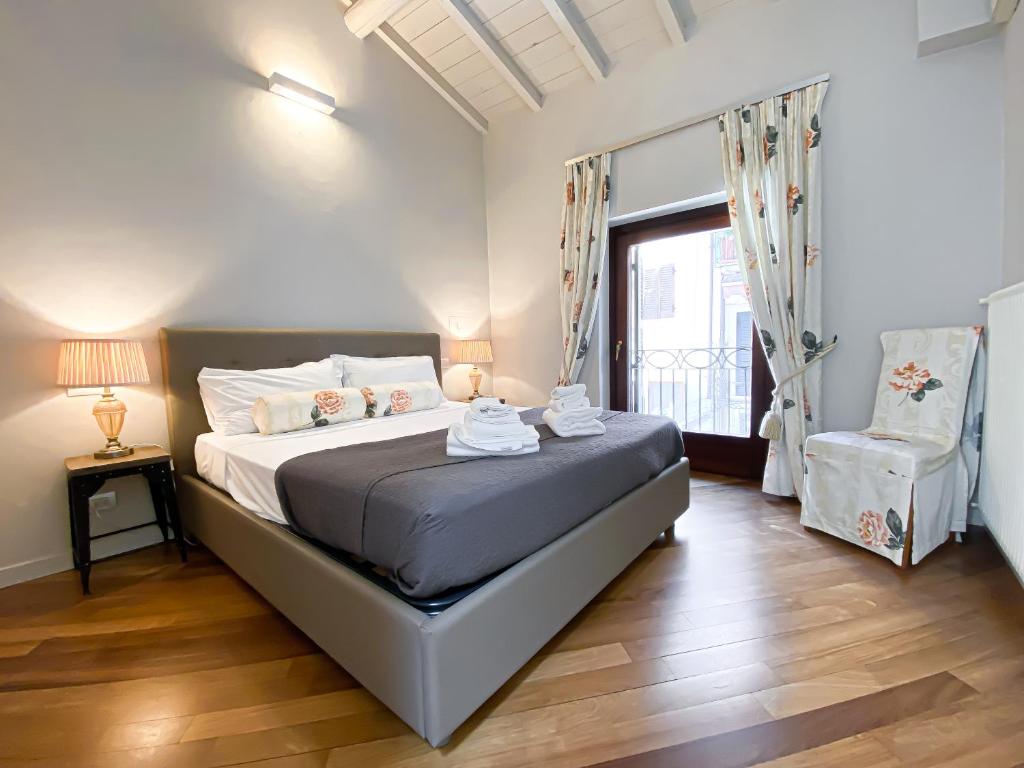 um quarto com uma cama, uma cadeira e uma janela em Rio Fiol Apartment em Verona