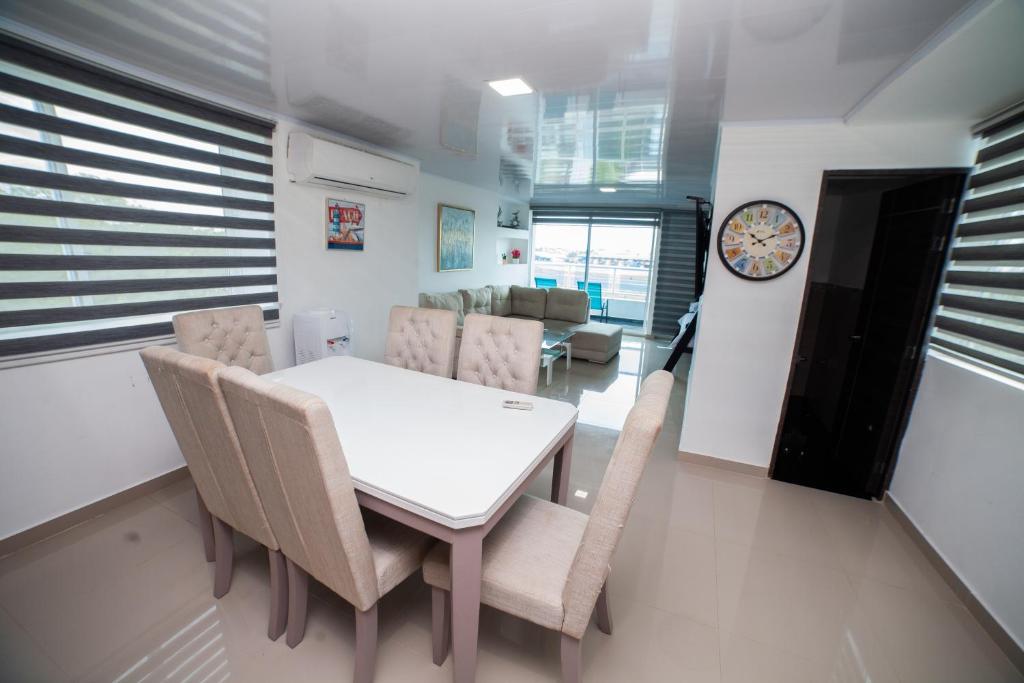 a dining room with a white table and chairs at APARTAMENTO FAMILIAR EN HOTEL in San Andrés