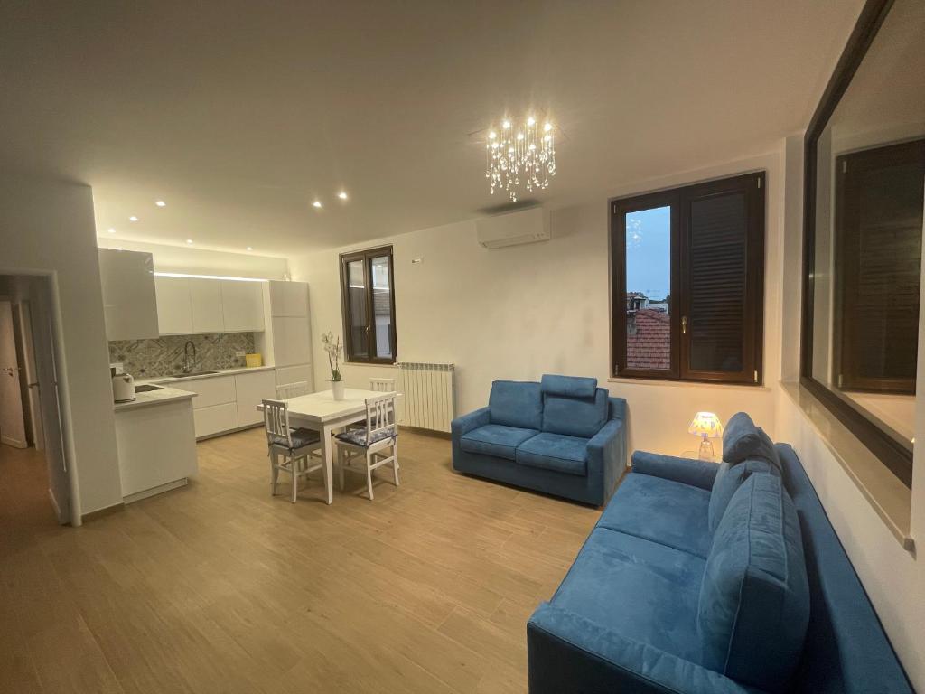 a living room with a blue couch and a kitchen at Casa Drema - Villa al mare con terrazza in Pescara