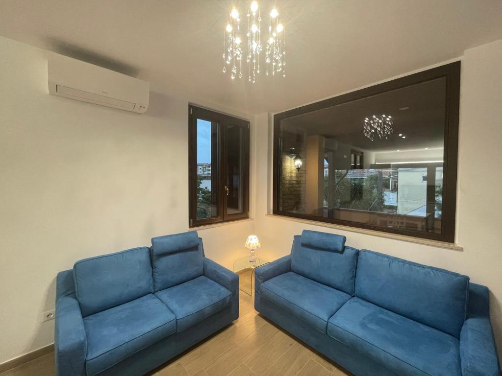 a living room with two blue couches and a chandelier at Casa Drema - Villa al mare con terrazza in Pescara