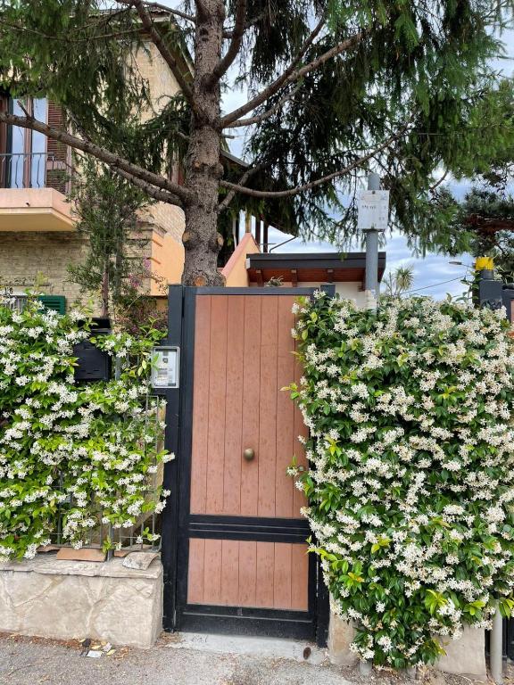 a wooden gate with flowers in front of a house at Casa Drema - Villa al mare con terrazza in Pescara