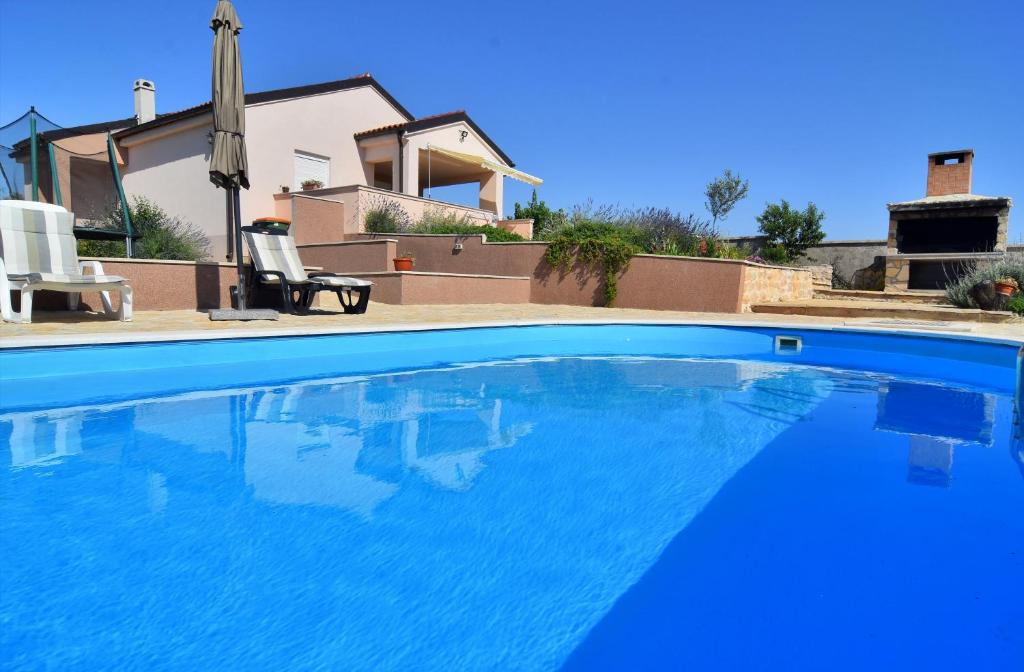 a large blue swimming pool in front of a house at Kuća za odmor Diana in Sukošan
