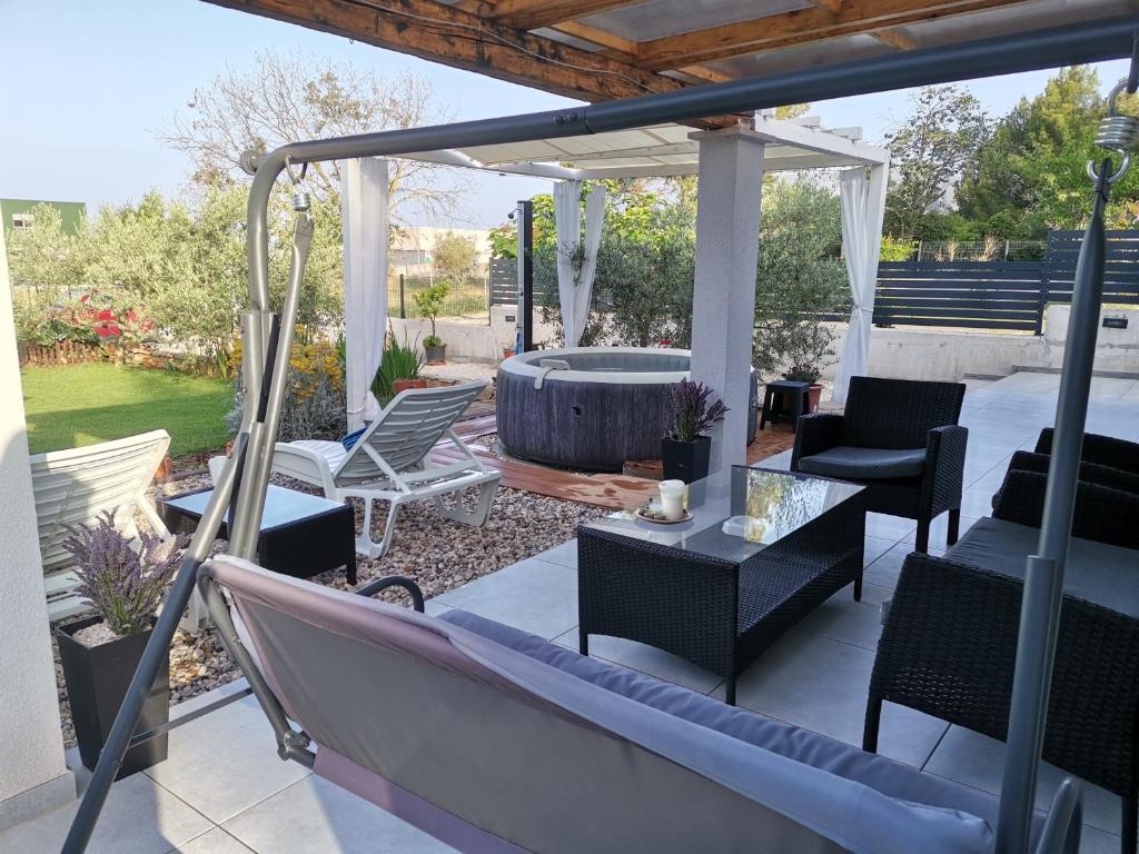 a patio with a hammock and a hot tub at Villa Molo in Novigrad Istria