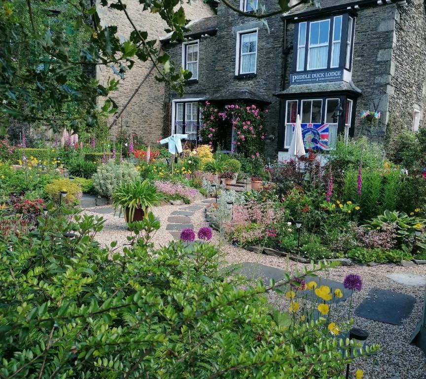 een tuin voor een gebouw met bloemen bij Puddle Duck Lodge – Adults Only in Bowness-on-Windermere