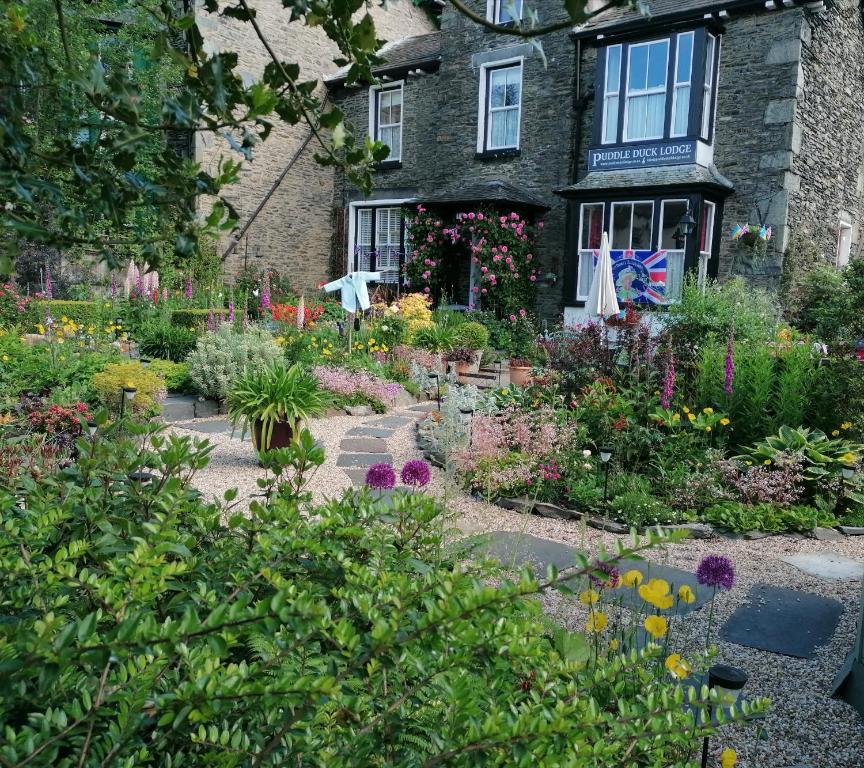 a garden in front of a building with flowers at Puddle Duck Lodge – Adults Only in Bowness-on-Windermere