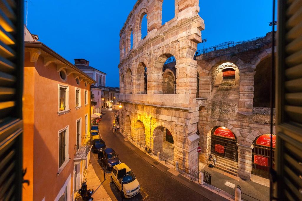 a view of an old building with cars parked on a street at Conte Manfredo and Donna Angelina Apartments with Breathtaking Arena Views in Verona in Verona