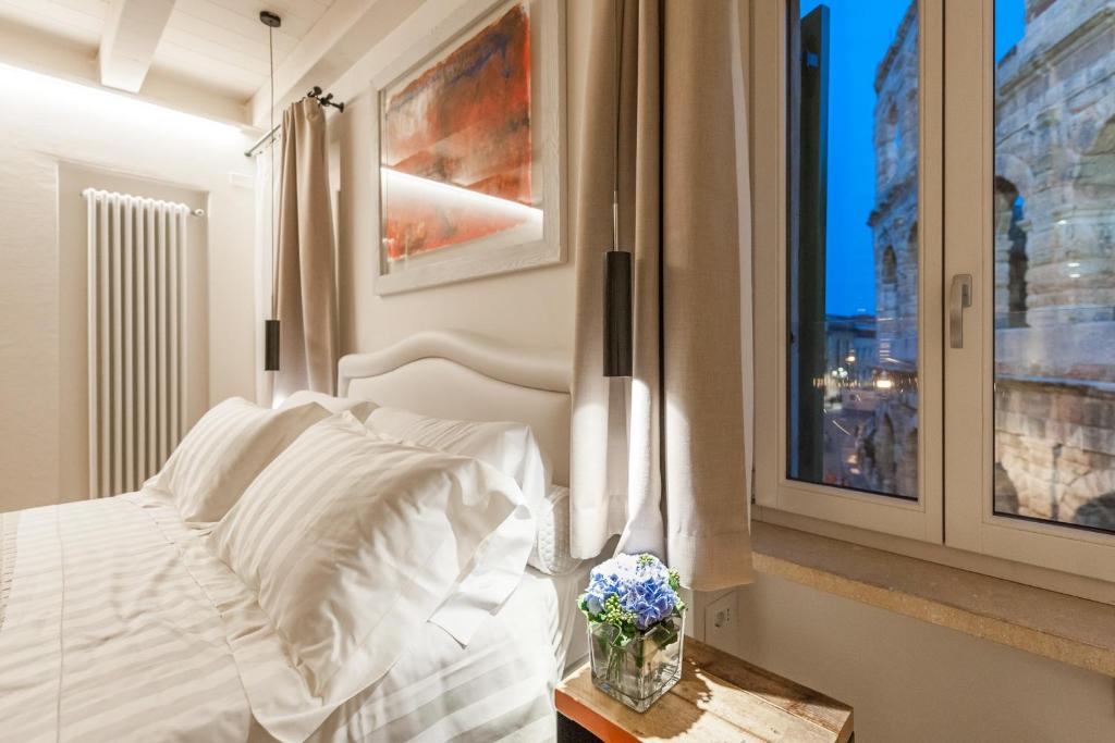 a bedroom with a white bed and a window at Verona Suites in Verona