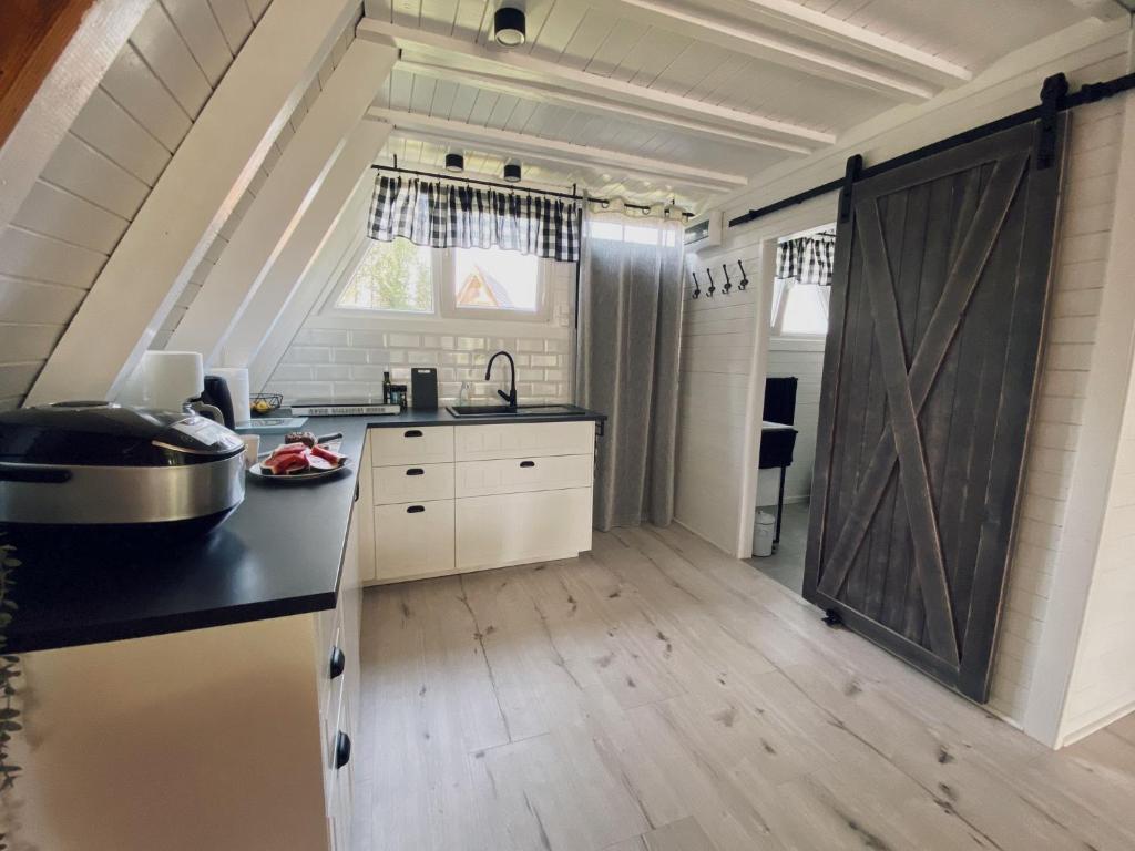 a kitchen with a black counter top and a wooden floor at Domek Letniskowy Dario in Ińsko