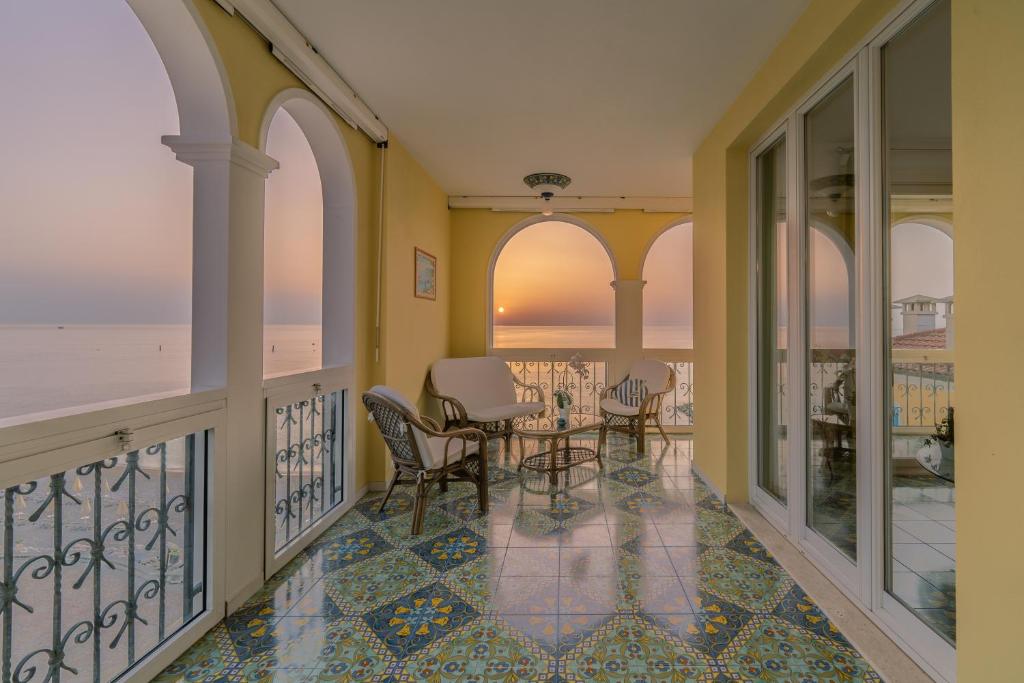 einen Balkon mit einem Tisch, Stühlen und Meerblick in der Unterkunft DOLF - Attico sul Mare in Porto Recanati