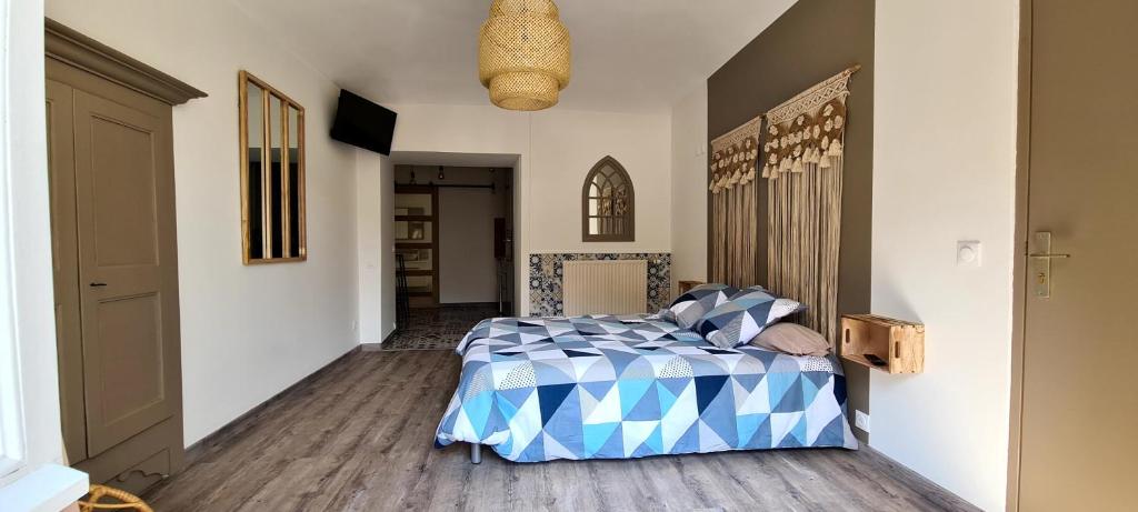 une chambre avec un lit avec une couette bleue et blanche dans l'établissement Gîte climatisé Baugallo Vêpres, à Saint-Montan