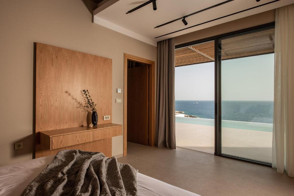 a bedroom with a bed and a view of the ocean at Limnionas Infinity Cave Villa in Kampíon