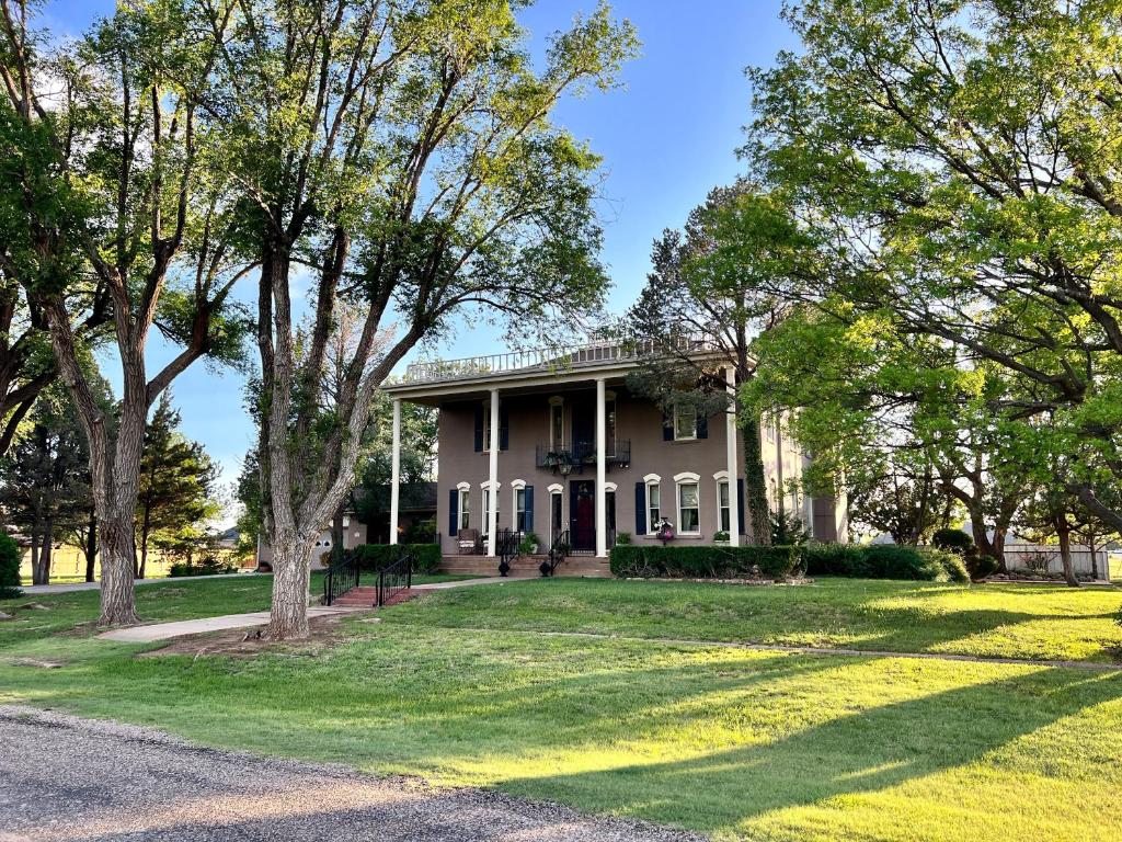 een groot huis met bomen ervoor bij THE CW HOUSE in Claude