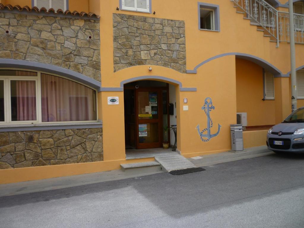 un edificio con una puerta y un coche aparcado delante en Hotel L'Ancora en Santa Teresa Gallura