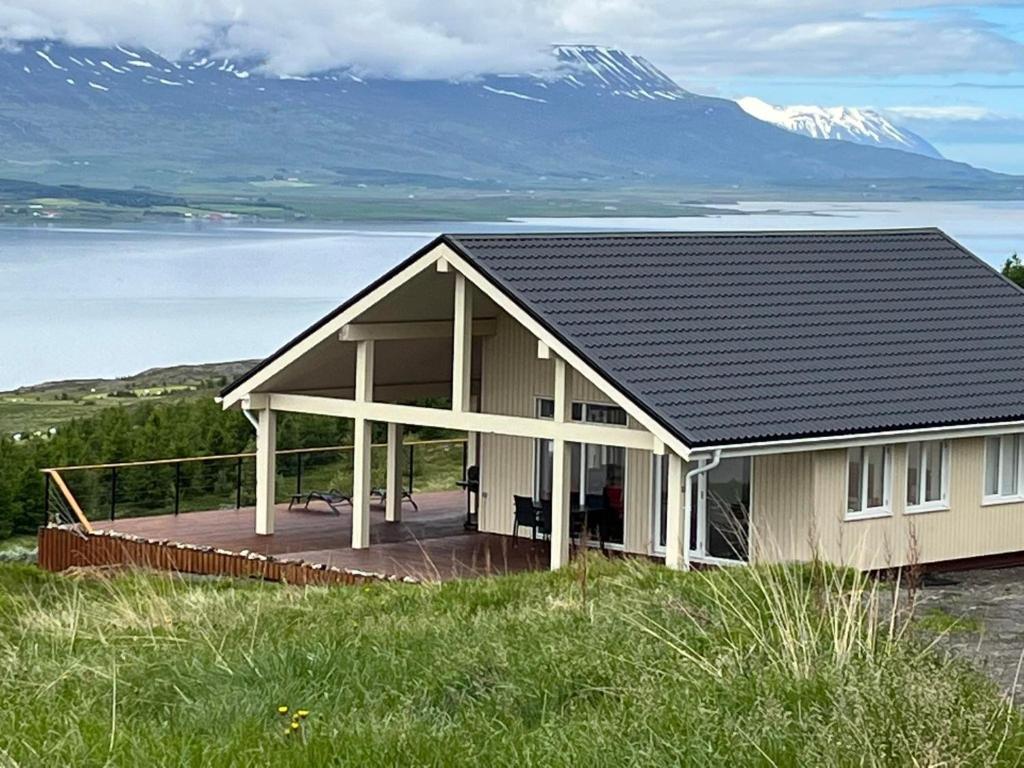 a house with a deck with a mountain in the background at Akureyri - cabin with an amazing view in Akureyri