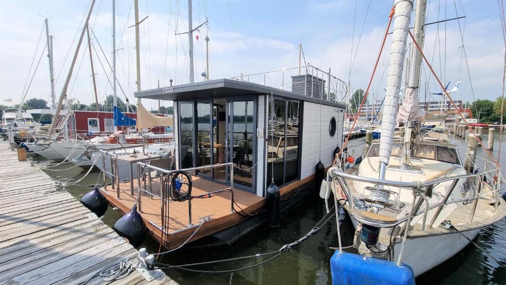 a small boat is docked at a dock at Hausboot Aava in Schleswig