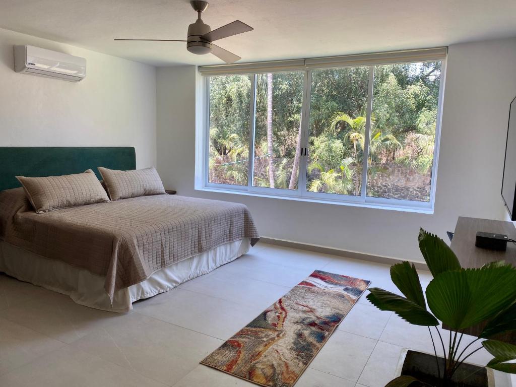 a bedroom with a bed and a large window at Hotel Marjaba in Cuernavaca