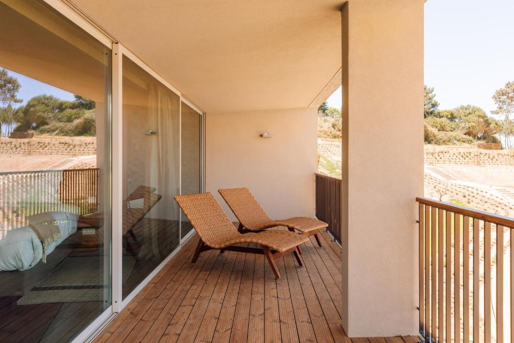 a balcony of a house with a chair on it at Immerso Hotel, a Member of Design Hotels in Ericeira