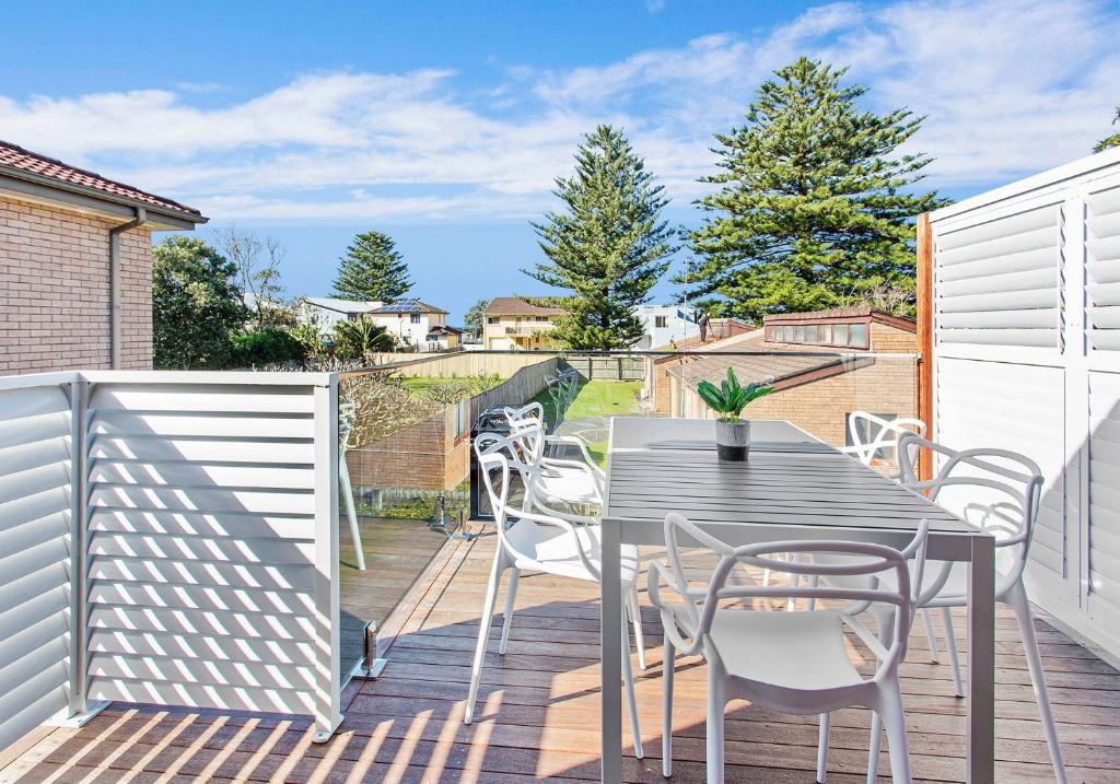 a patio with a table and chairs on a deck at Beach Breeze in Gerringong