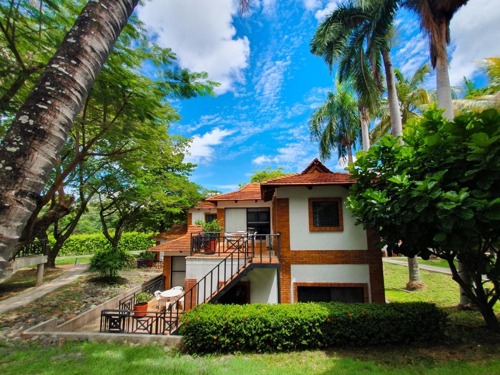 a house with a balcony and palm trees at On Vacation Girardot Resort in Girardot