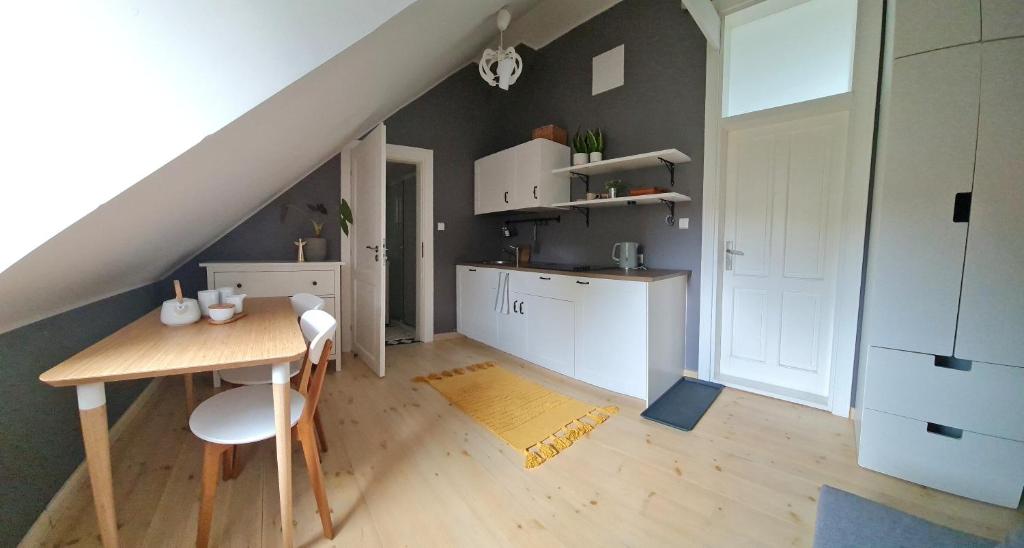 a kitchen and dining room with a table and a staircase at Klimatyczny apartament w Oliwie in Gdańsk