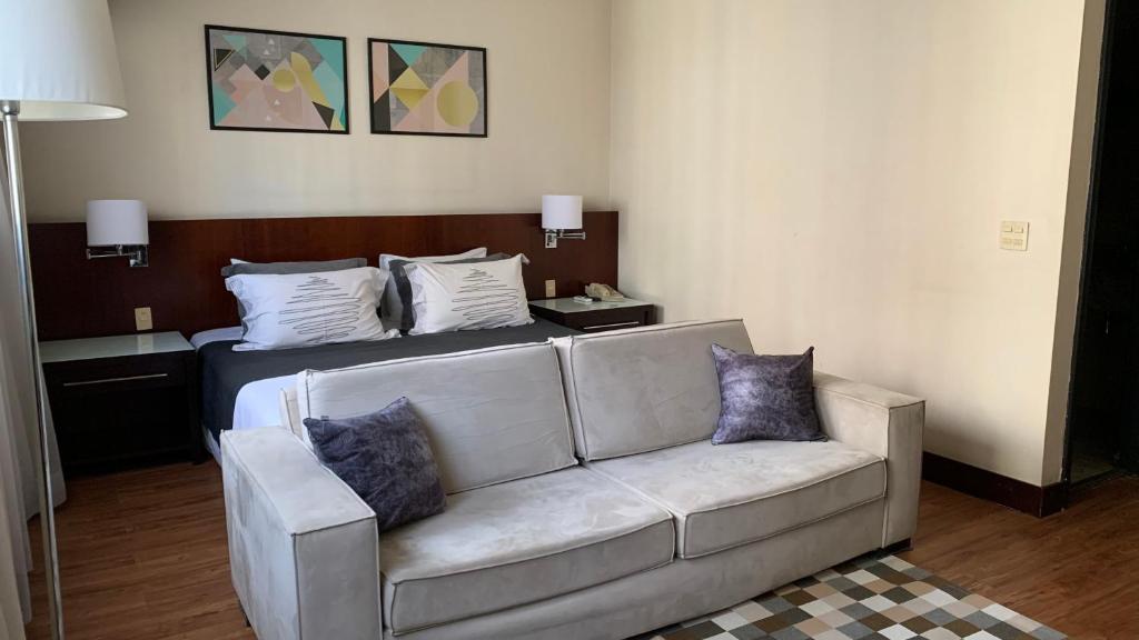 sala de estar con sofá y cama en Wynd Berrine, en São Paulo