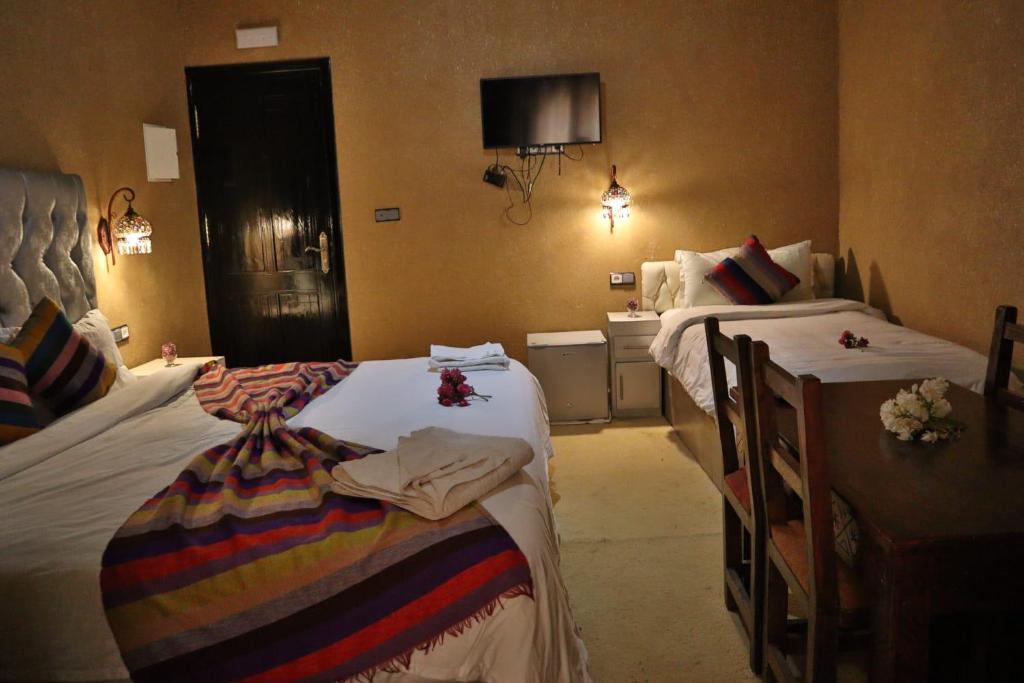 a hotel room with two beds and a sink at Residence Touristique Merzouga in Merzouga