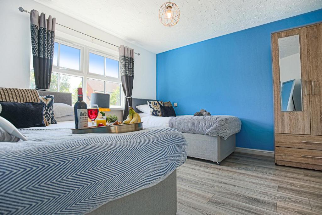 um quarto com 2 camas e uma parede azul em Delightful 2 BED APARTMENT for BICESTER OUTLET SHOPPING by Platinum Key Properties em Bicester