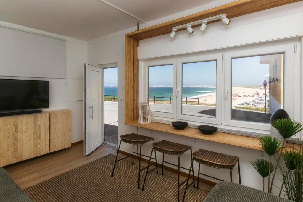 uma sala de estar com vista para a praia em Vista espectacular playa de Supertubos, Peniche em Atouguia da Baleia