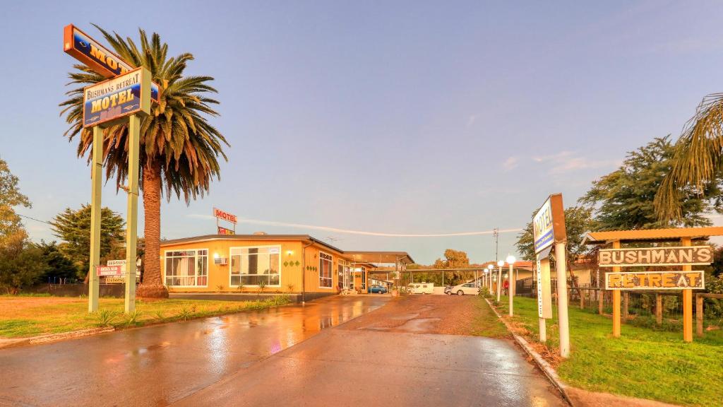 una strada bagnata di fronte a un edificio di BUSHMANS RETREAT MOTOR INN a Gundagai