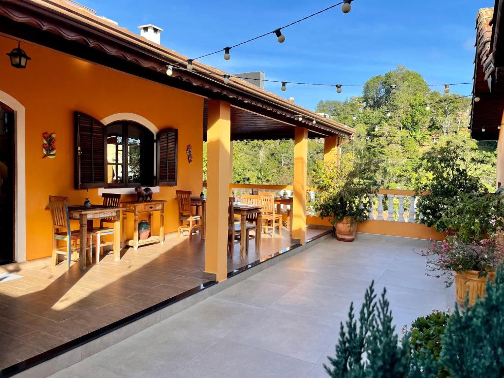 an outdoor patio with wooden tables and chairs at Hotel do Parque - Cunha in Cunha