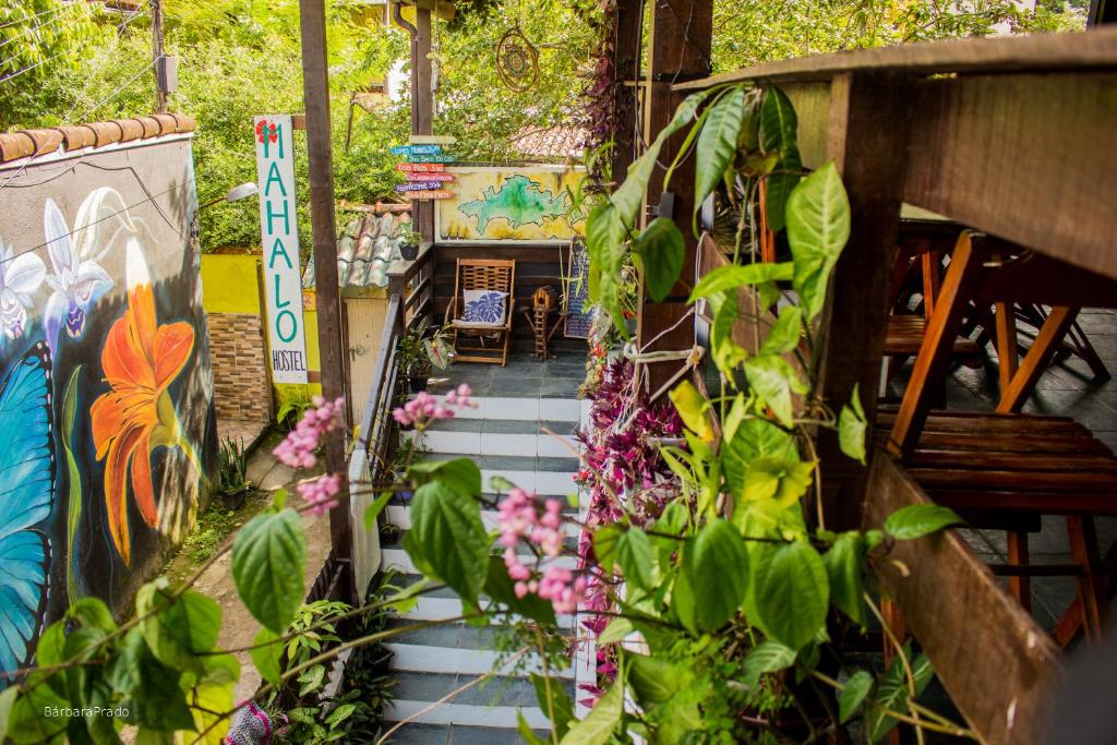 Un paseo con plantas y un banco en un jardín. en Mahalo Hostel, en Abraão