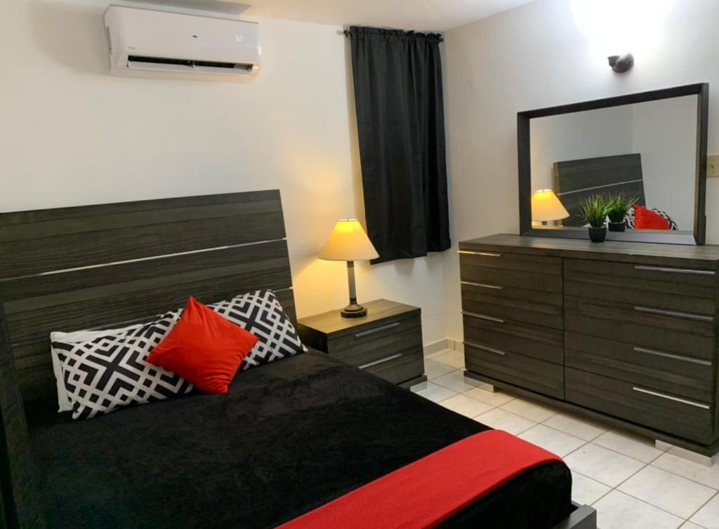 1 dormitorio con 1 cama con tocador y espejo en CHILL SPOT, en Ceiba