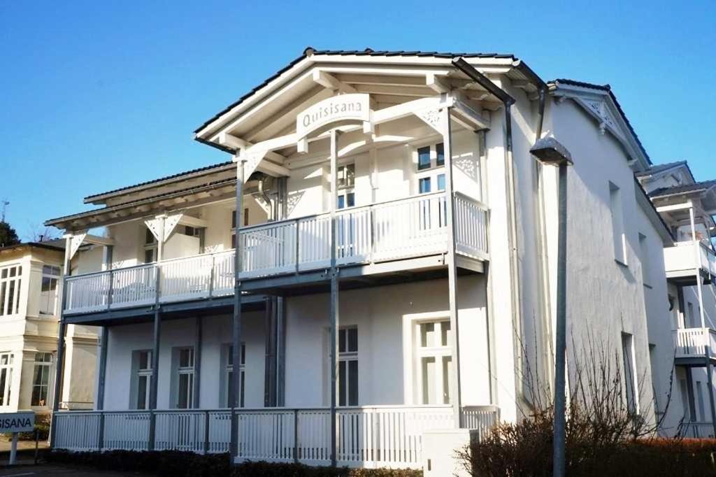 a white apartment building with a sign on it at Haus Quisisana - Fewo 1 - 4549 in Göhren