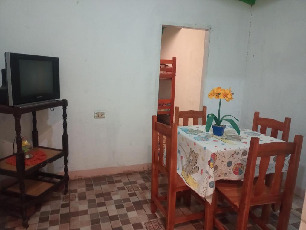 ein Esszimmer mit einem Tisch und einem TV in der Unterkunft Flia brover (Lalo) in Puerto Iguazú