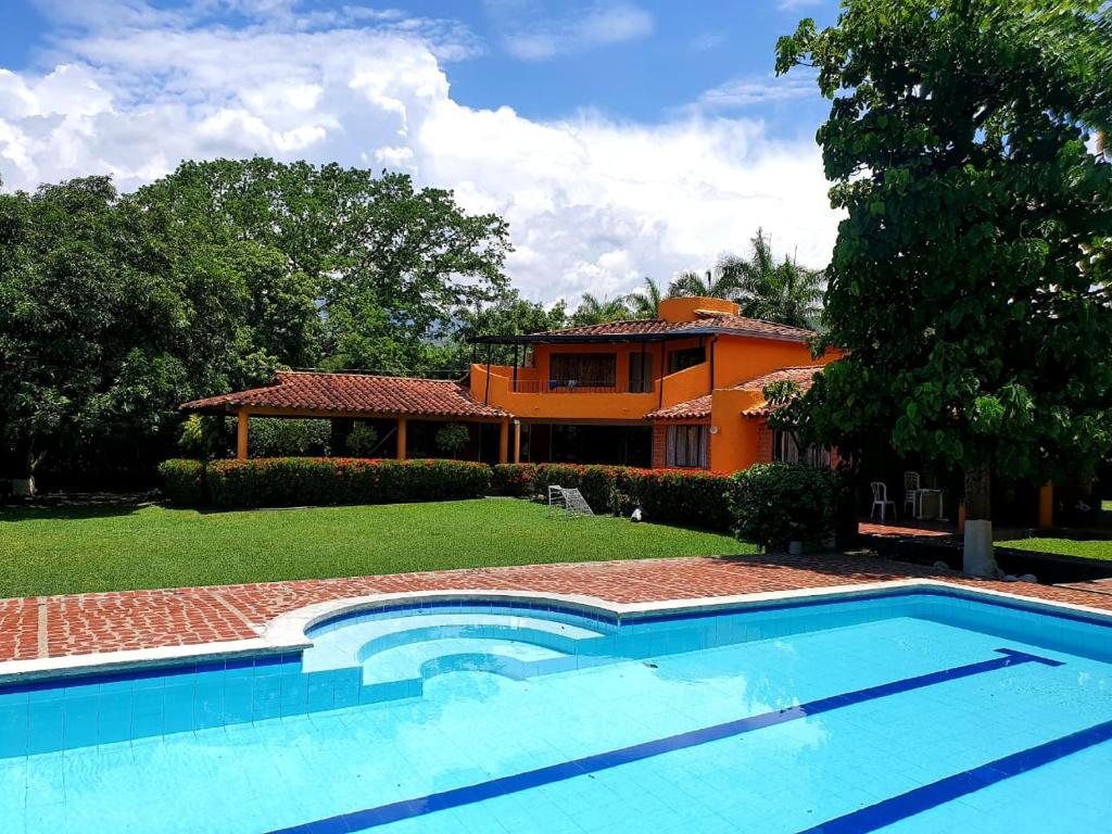 - une piscine en face d'une maison dans l'établissement Finca Hacienda el Castillo Santa Fe de Antioquia, à Santa Fe de Antioquia