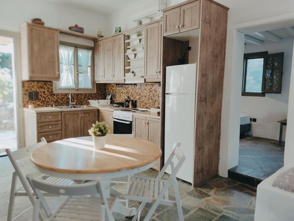 uma cozinha com uma mesa e cadeiras e um frigorífico em Melia Sifnos House em Platis Yialos Sifnos