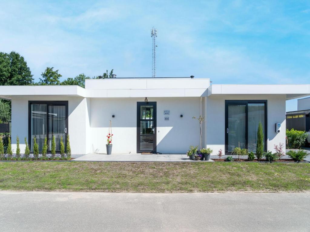 een wit gebouw met een deur en ramen bij Holiday Home in Harderwijk with Private Outdoor Jacuzzi in Harderwijk