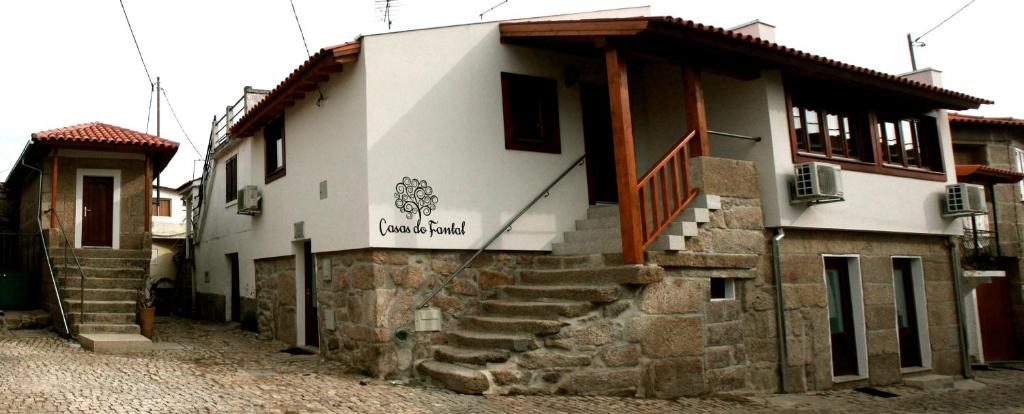 a building with stairs and a sign on it at Casas do Fantal in Vale de Salgueiro
